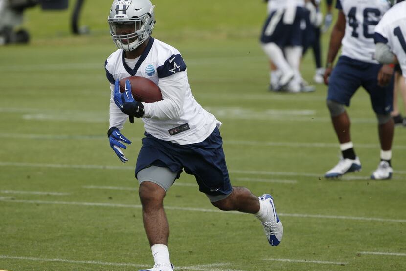 Dallas Cowboys running back Ezekiel Elliott (21) runs a drill during organized team...