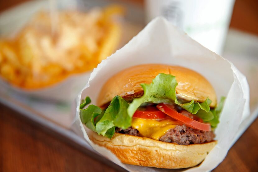 A plate of ShackBurger, cheese fries and Salted Toffee shake at Shake Shack in Plano, Texas,...