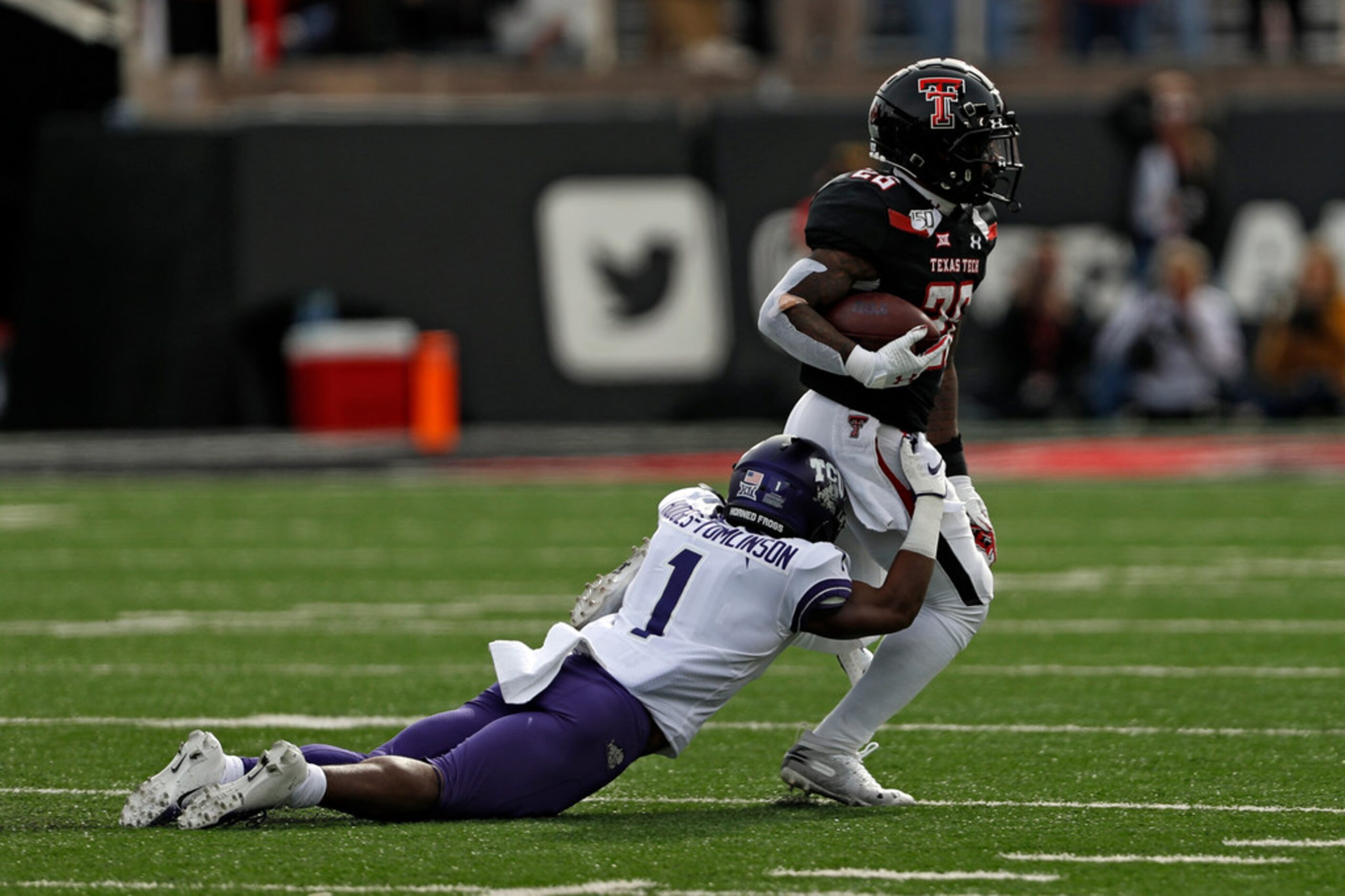 TCU's Tre'Vius Hodges-Tomlinson (1) tackles Texas Tech's Ta'Zhawn Henry (26) during the...