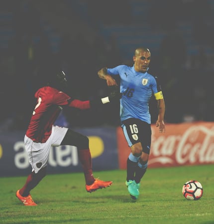 Uruguayan footballer Maximiliano Pereira (R) vies for the ball with Trinidad and Tobago's...