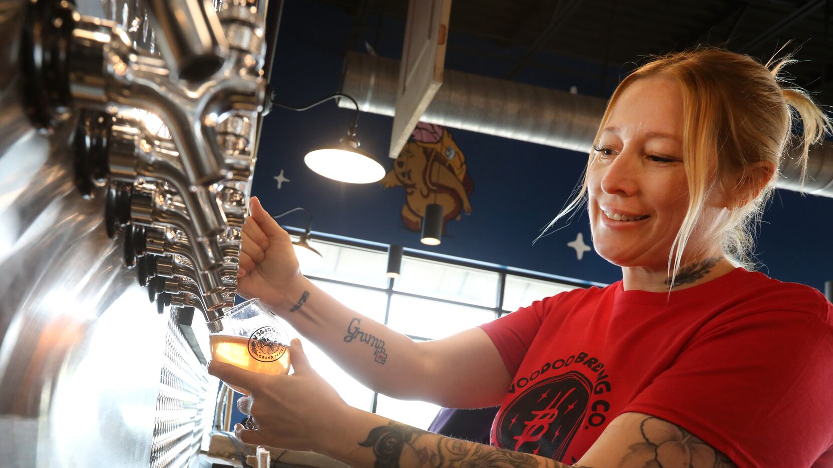 Head bartender Dawn Larios tests the newly installed beer taps at Voodoo Brewing in Grand...