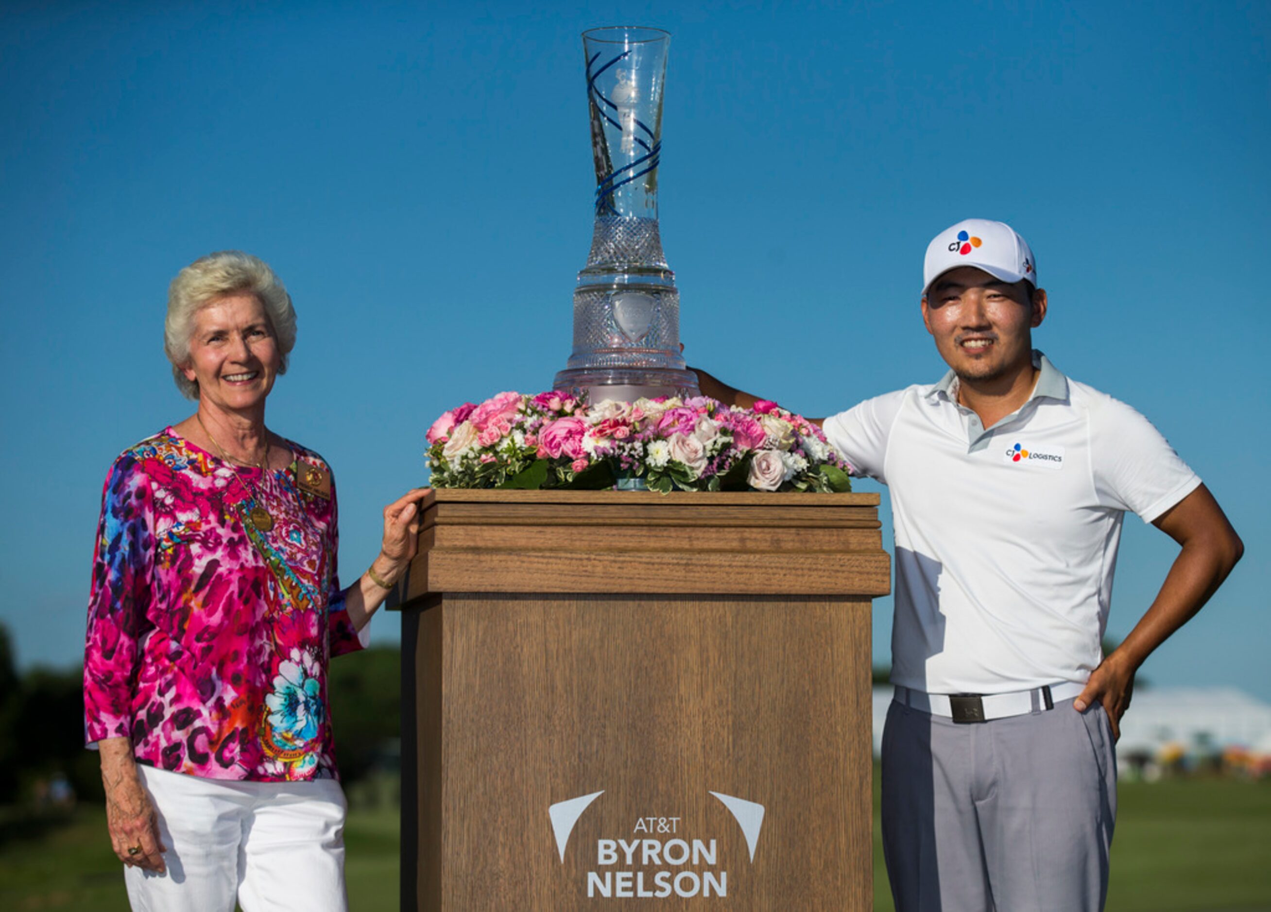 Peggy Nelson, wife of Byron Nelson, and Sung Kang pose with the AT&T Byron Nelson trophy...