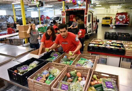 Rosalia Zarate, 50, left, and Erian Calvillo, right, finish packing donated foods to be...