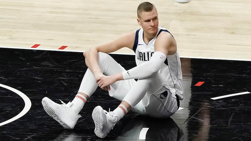 Dallas Mavericks center Kristaps Porzingis sits on the court after a foul during the second...