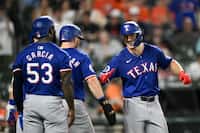Texas Rangers' Wyatt Langford, right, celebrates his three-run home run with Adolis García...