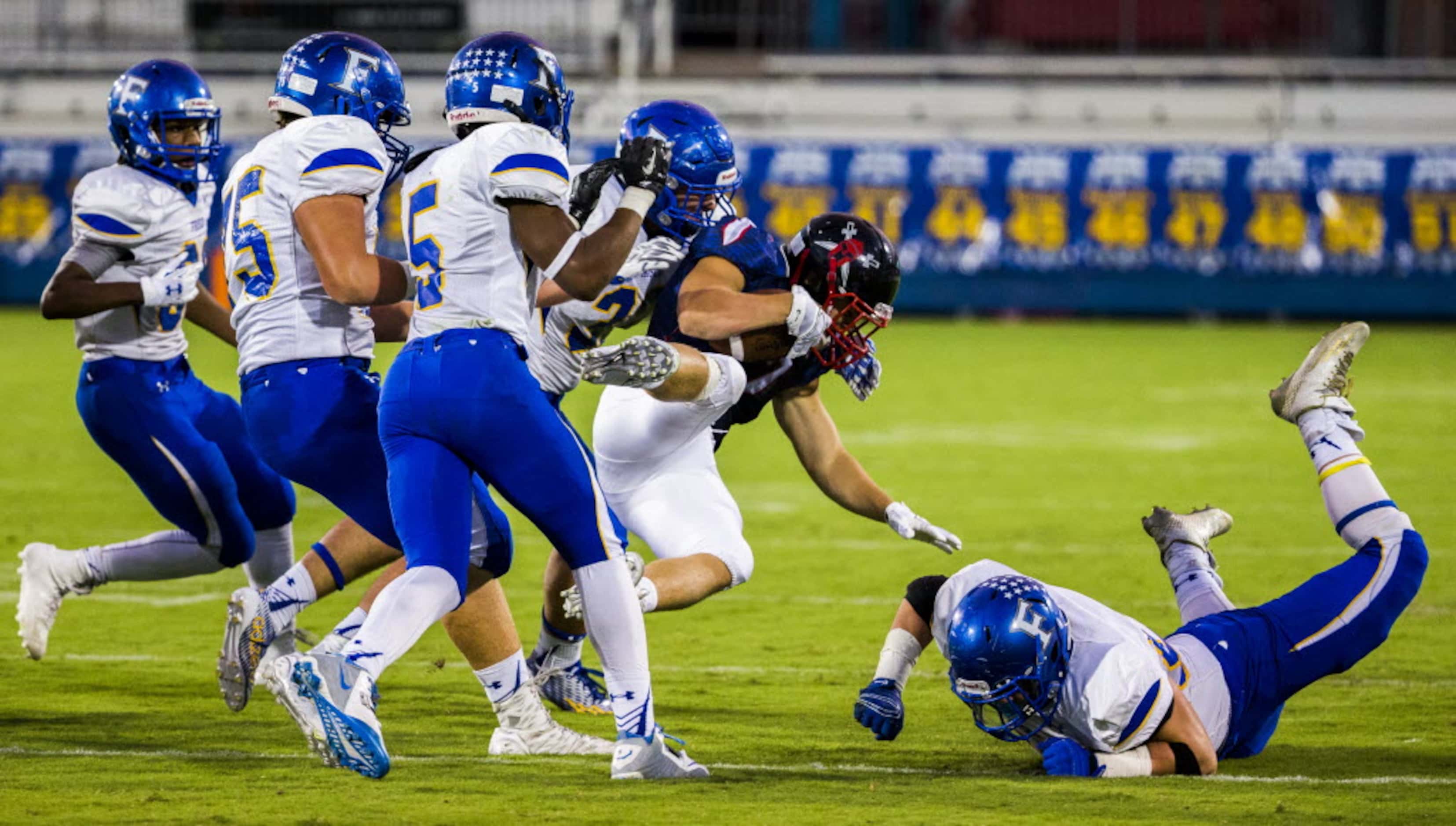 Frisco Centennial defensive back Brock Hawkins (7) is tackled by a group of Frisco offensive...