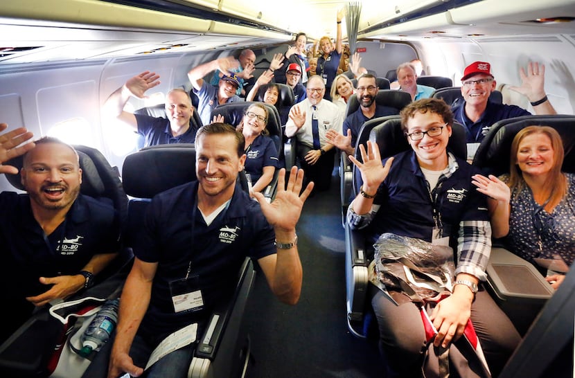 American Airlines employees pose for photos aboard one of the final MD-80 jets departing for...