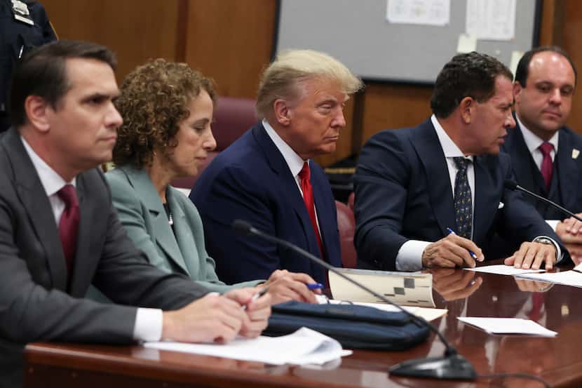 Former President Donald Trump sits at the defense table for his arraignment with his...