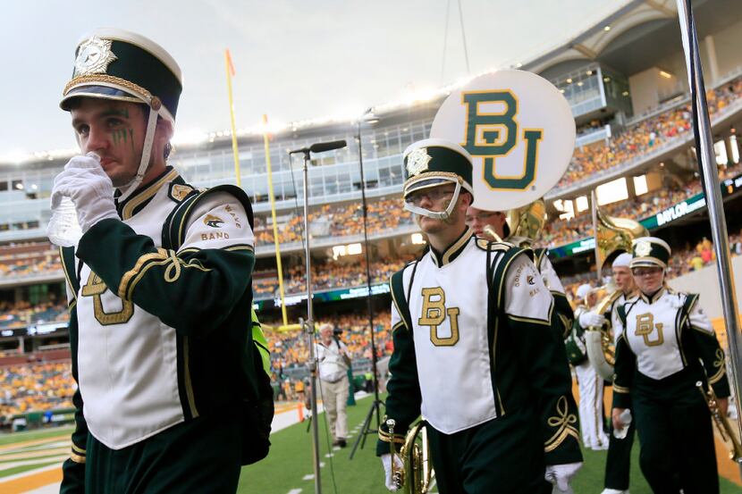 Members of the Baylor Marching Band clear the field during a weather delay of the first...