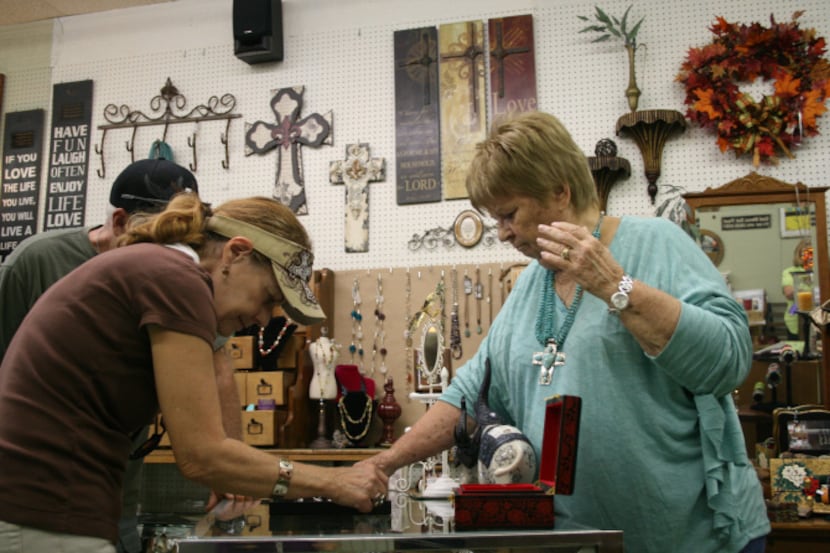 Pat Malone, owner of Ten of Arts, which she co-owns with Lynne Hosid, displays some of her...