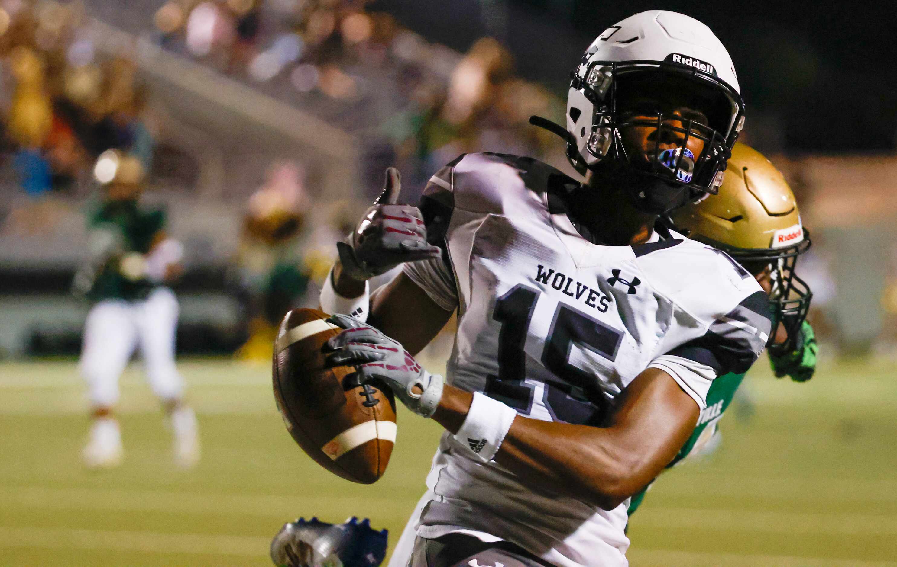 Mansfield Timberview wide receiver Titus Evans (15) throws up a hand sign after crossing...