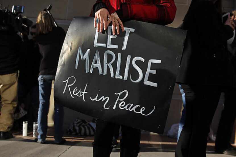A demonstrator holds a sign supporting the family of Marlise Munoz in their fight to have...