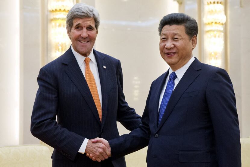 U.S. Secretary of State John Kerry, left, poses with Chinese President Xi Jinping prior to...