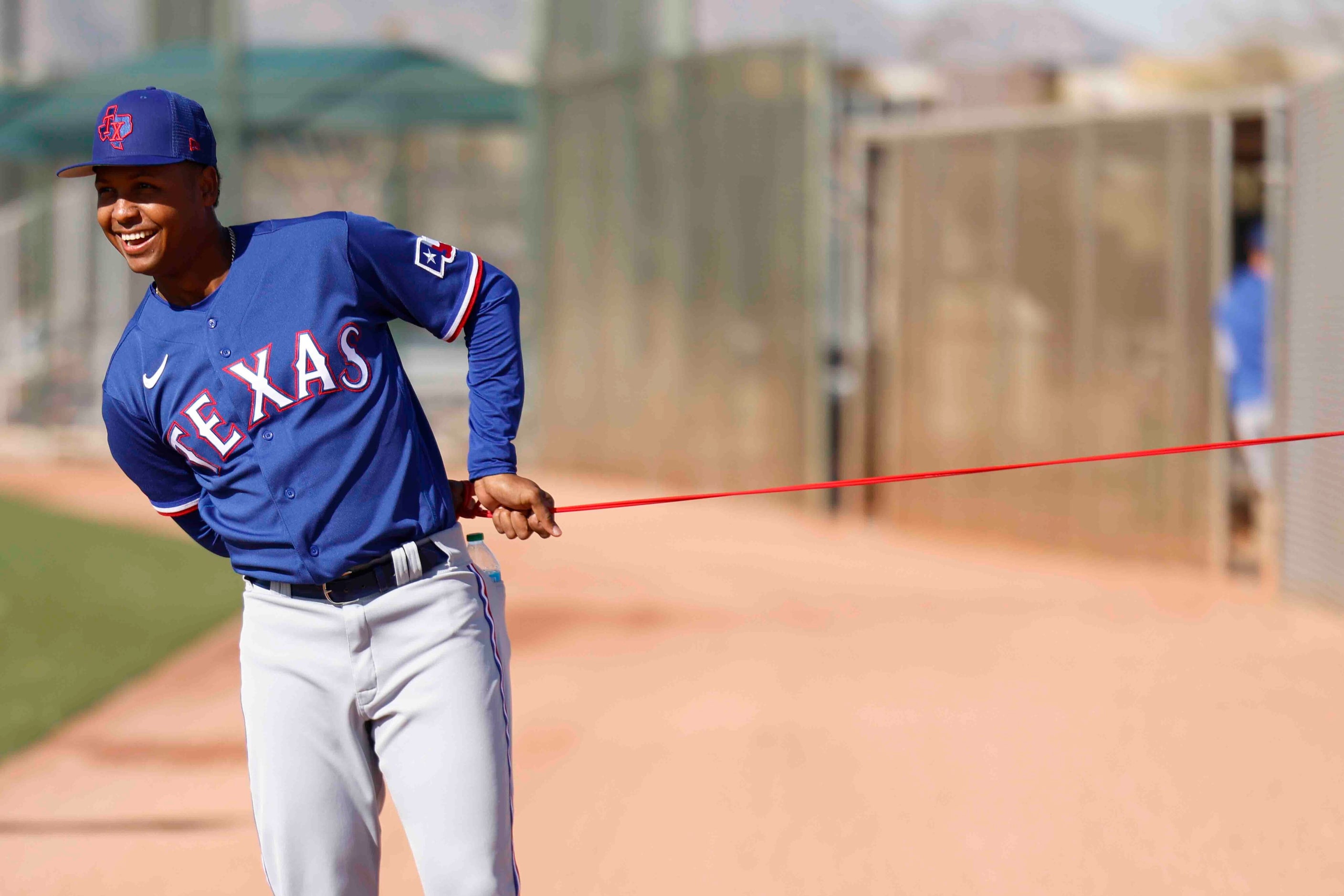 Texas Rangers Pitcher Jose Leclerc stretches on a practice field during a spring training...