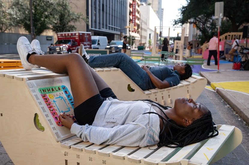 Princess Mazagwu reclines in a plywood rocker during the Better Block Foundation's “Creating...