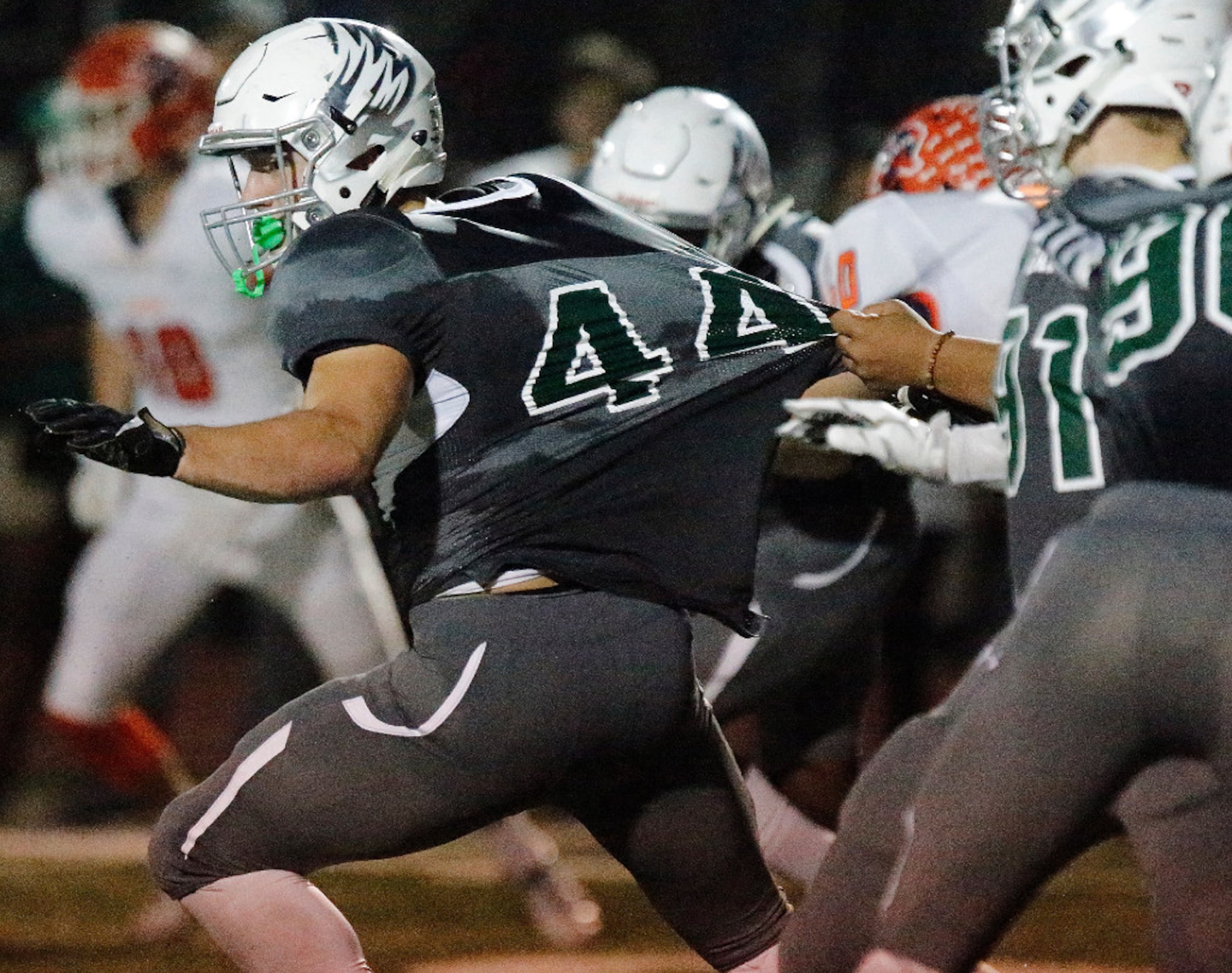 Prosper High School linebacker John Brannon (44) is held by the jersey during the first half...