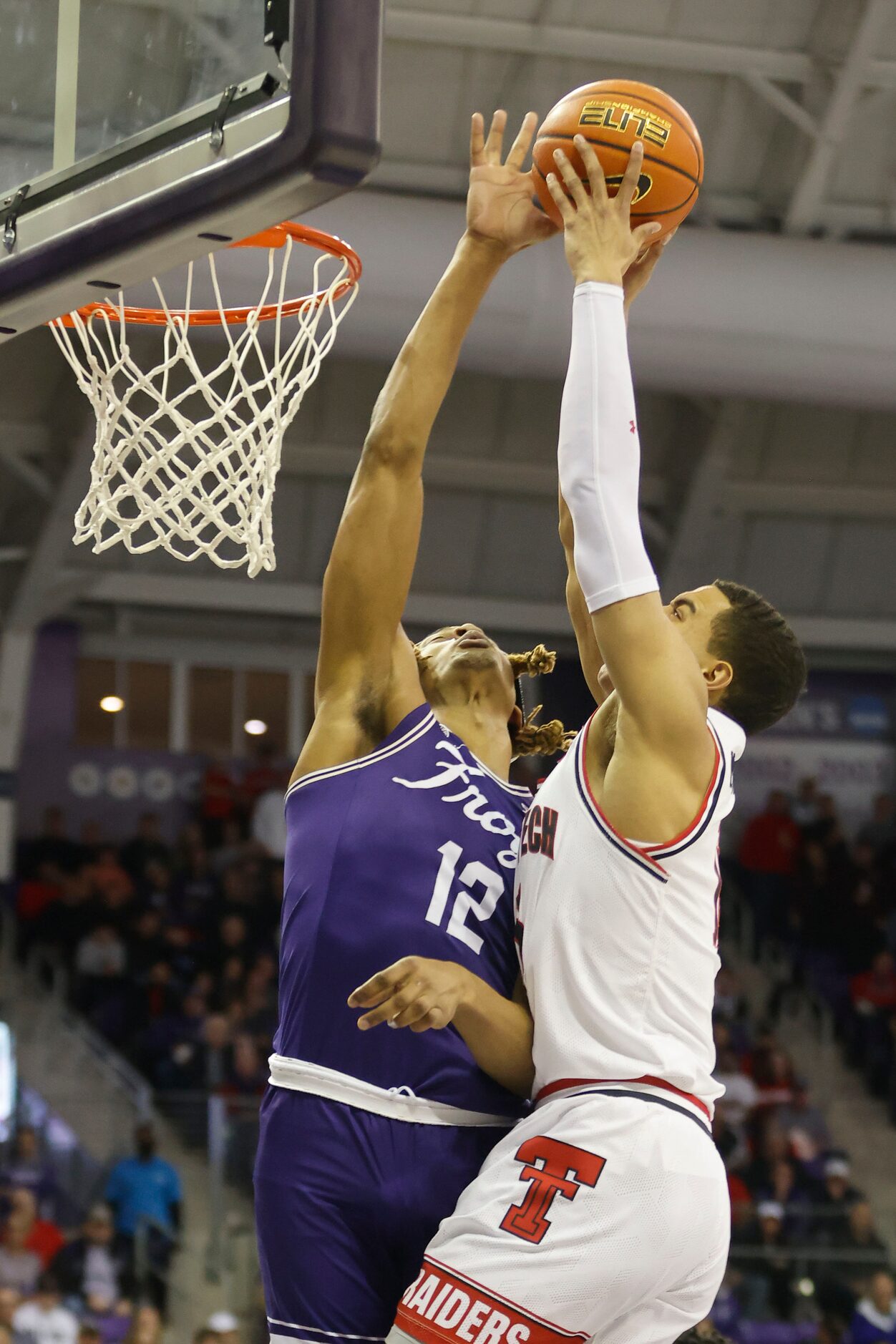 TCU forward Xavier Cork (12) blocks a shot by Texas Tech guard Kevin McCullar (15) during...