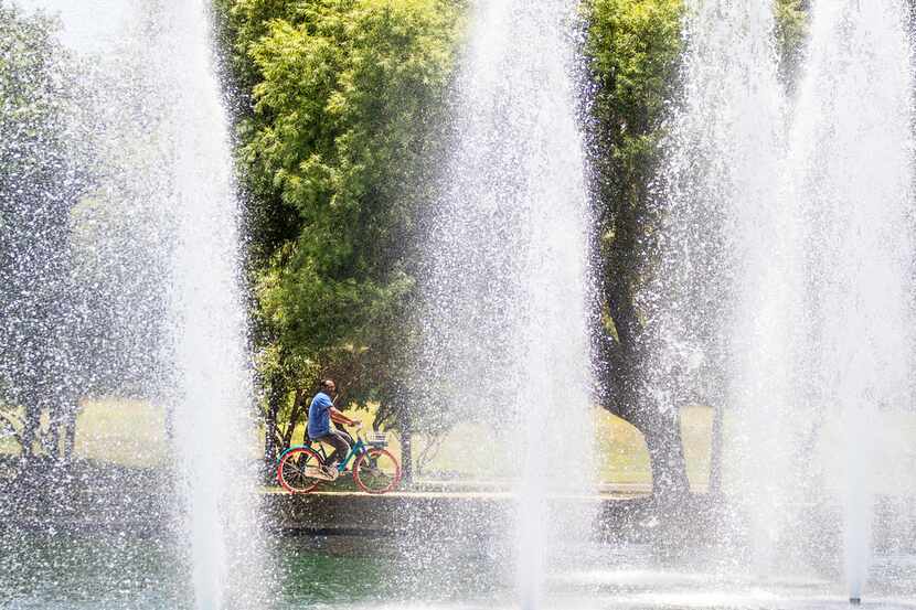 A man rides a bike on Capital One's Plano campus on June 13.