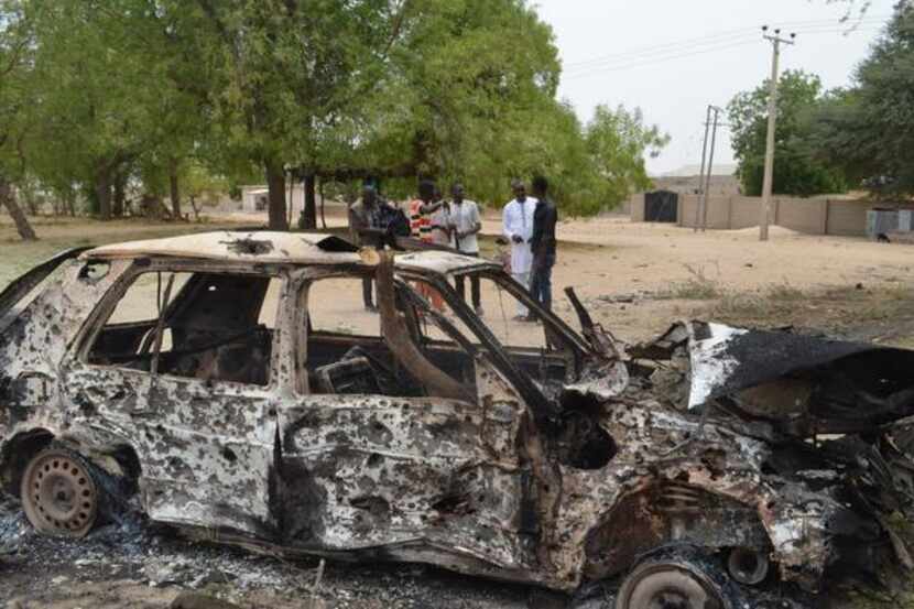 
People inspect the remains of a car used in a suicide bomb in Maiduguri, Nigeria, on March...