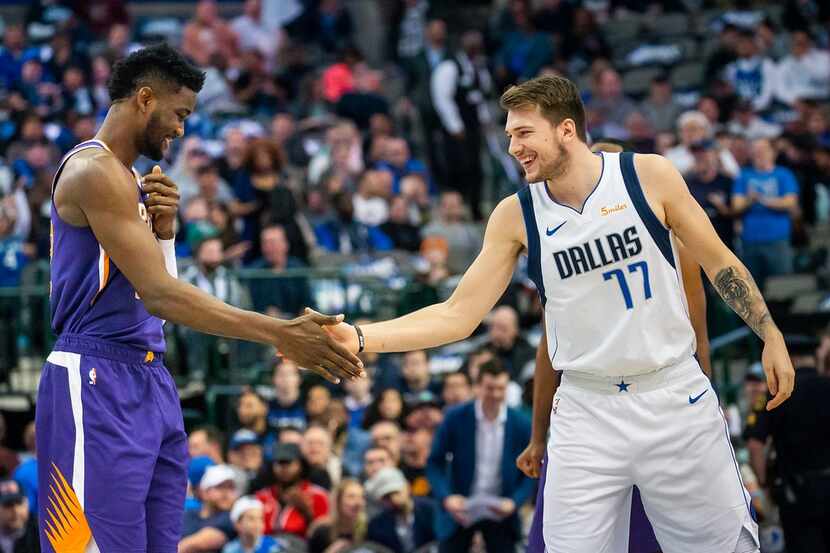 Dallas Mavericks forward Luka Doncic (77) shakes hands with Phoenix Suns center Deandre...