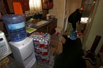  Resident Demetrius "People" Blair carries a 5-gallon water bottle that the county and a...