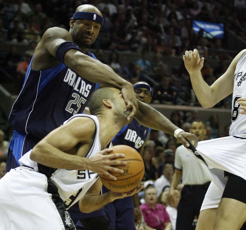 Dallas Mavericks Erick Dampier (25) grabs the face of San Antonio Spurs Tony Parker (9) and...