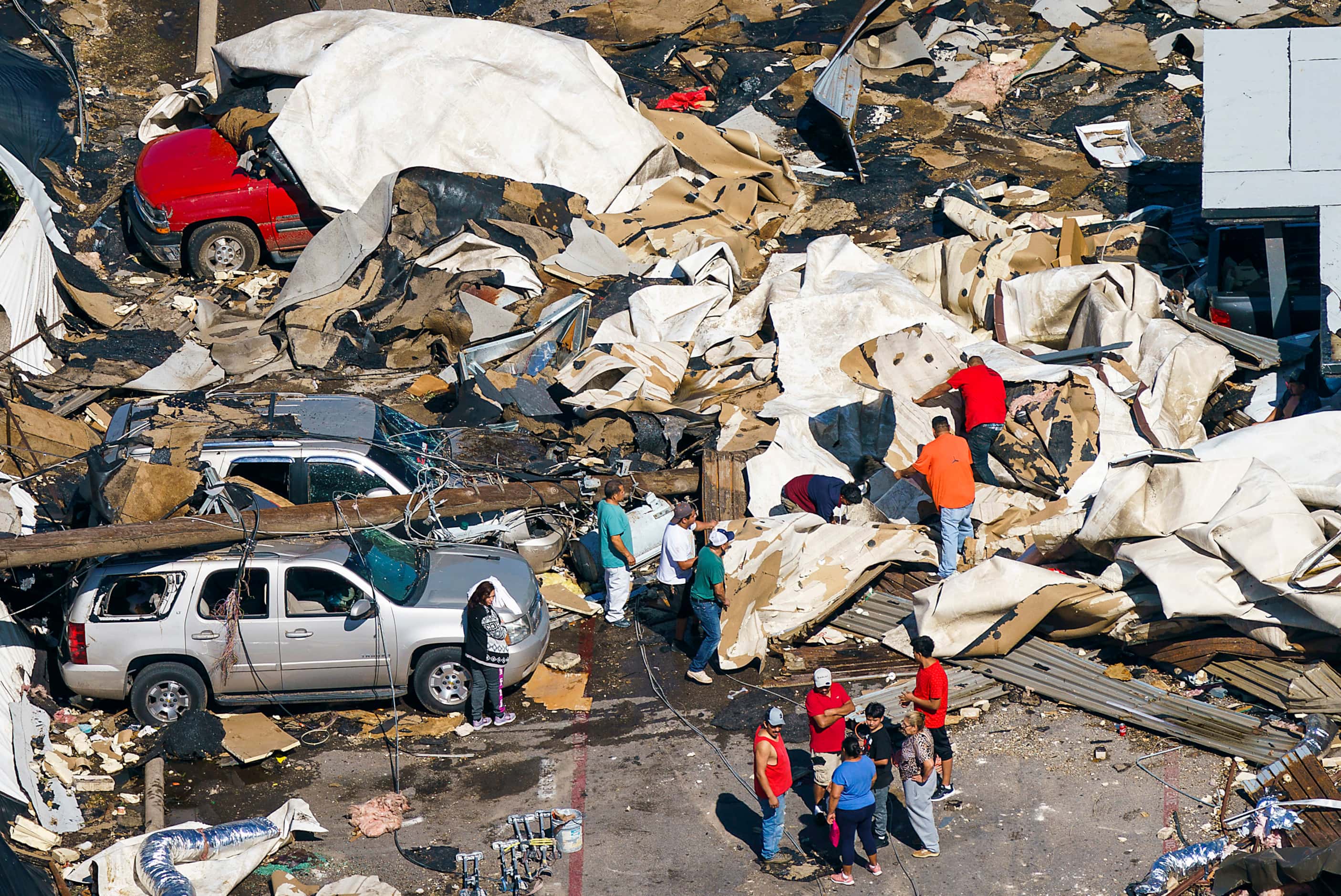 People pick through the rubble left by a tornado near Walnut HIll Lane and Denton Drive on...