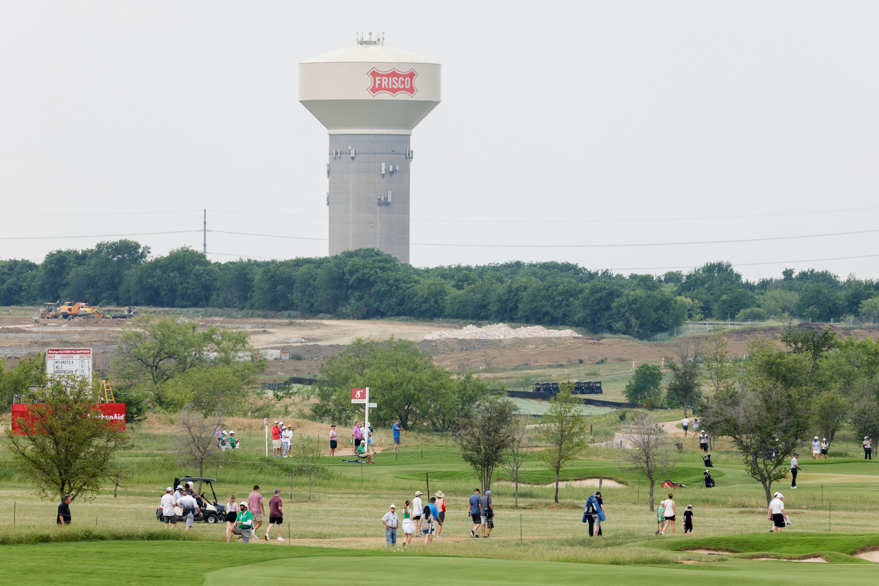 Golf fans walk between holes during the first round of the 83rd KitchenAid Senior PGA...