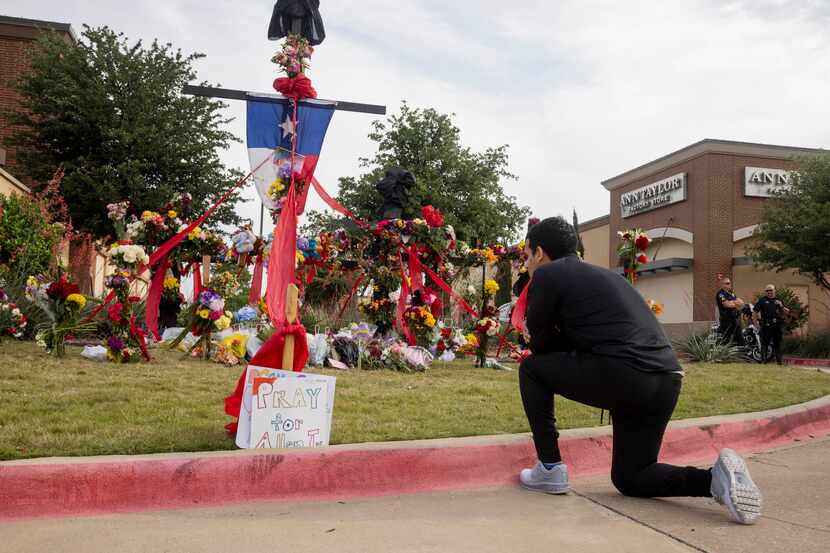 Juan Bueno of Richardson prayed in front of the memorial outside the mall honoring the...