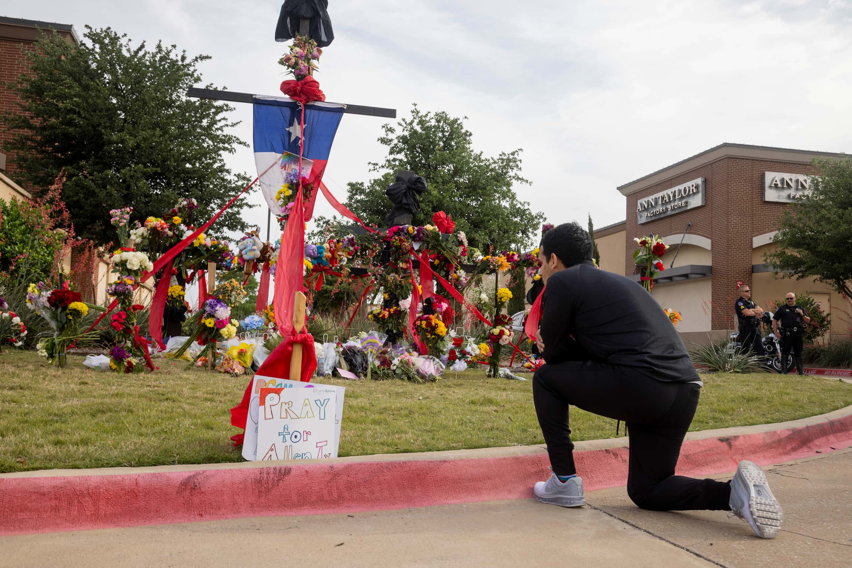 Juan Bueno of Richardson prays in front of the memorial outside the mall honoring the...
