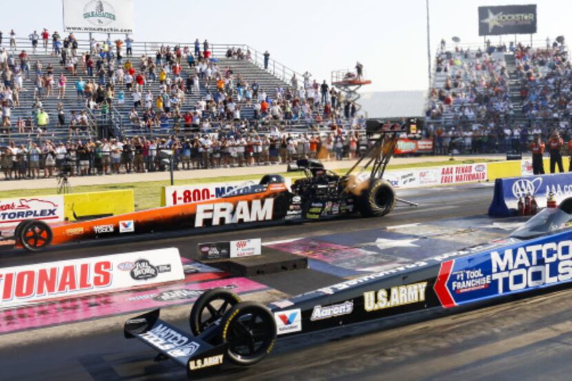 Spencer Massey, far, races Antron Brown in the final race of the Top Fuel division in the...