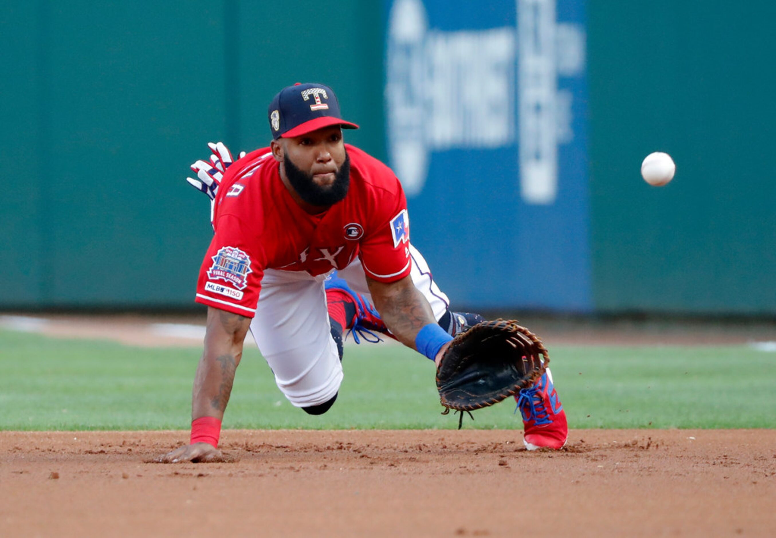 Texas Rangers first baseman Danny Santana dives forward to field a grounder by Los Angeles...