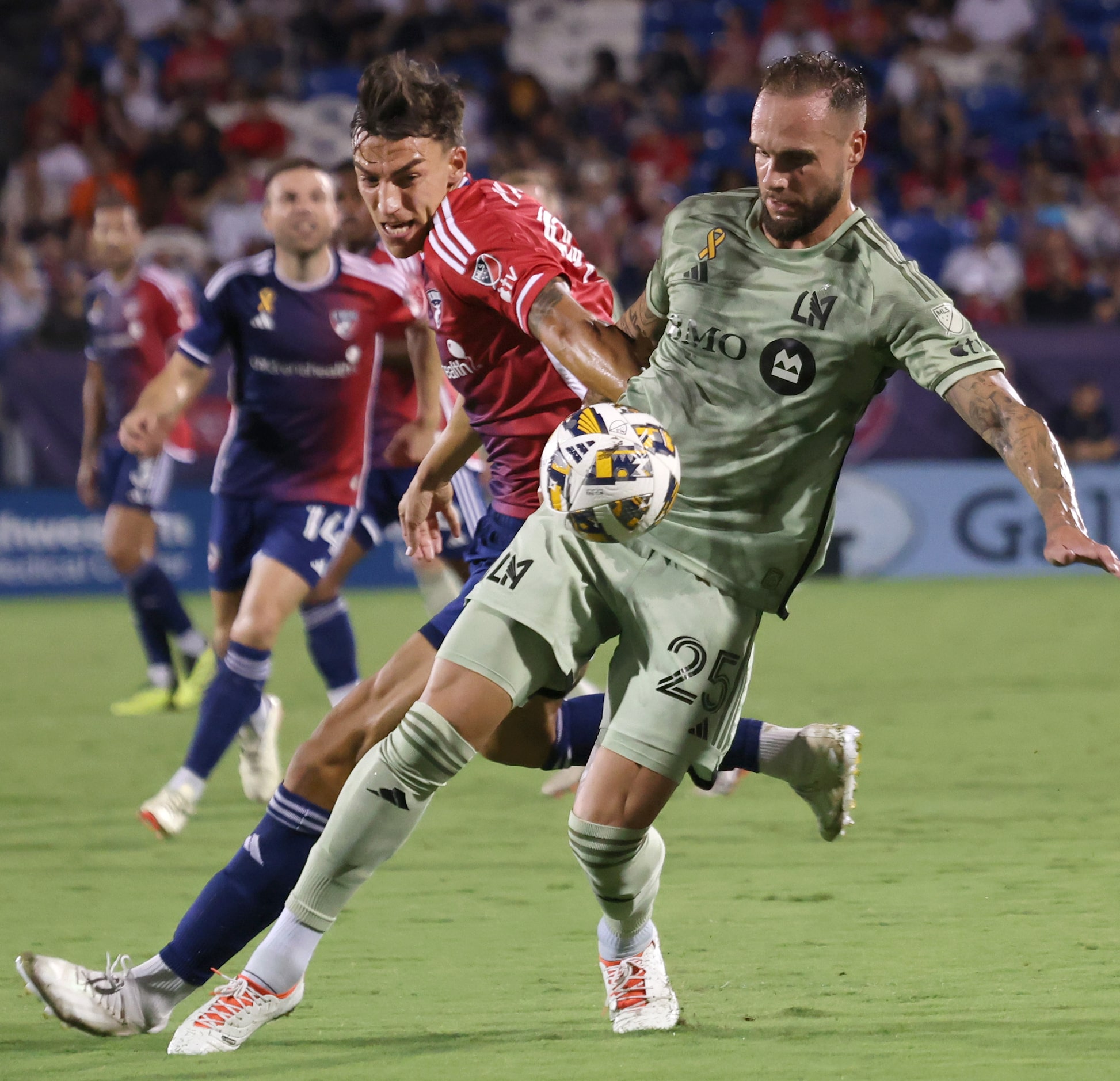 FC Dallas attacker Peter Musa (9), left, battles with LAFC defender Maxime Chanot (25) for...