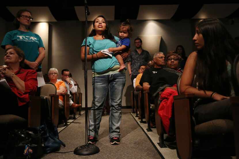 Mandy Lee-Vielma, who has three children in DISD, holds onto her fourth child, Grayson...