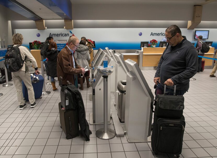 Travelers checked their luggage before boarding an American Airlines flight in Terminal C at...