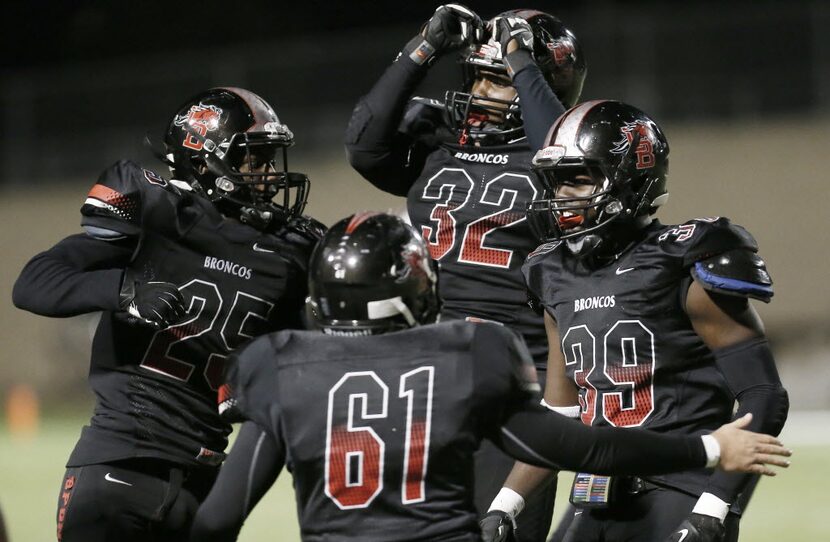 Mansfield Legacy junior defensive lineman Craig Nealy (32) is congratulated by teammates...