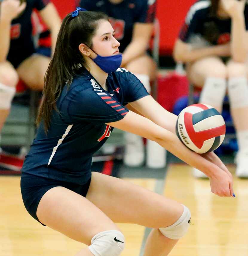 Grapevine High School outside hitter Janet Demarrais (12) receives a serve during game one...