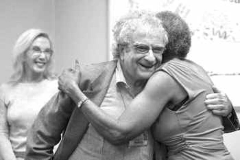 Dr. Joel Feiner, flanked by his wife, Dr. Gail Alexander, gets a hug from Helen Sorrells...