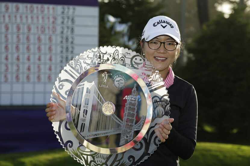 Lydia Ko of New Zealand poses with her trophy on the 18th green of the Lake Merced Golf Club...