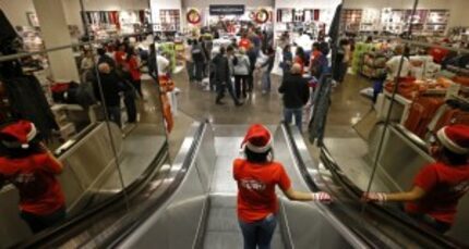  Employee Saghar Borousham rides down an escalator to start helping customers at J.C. Penney...