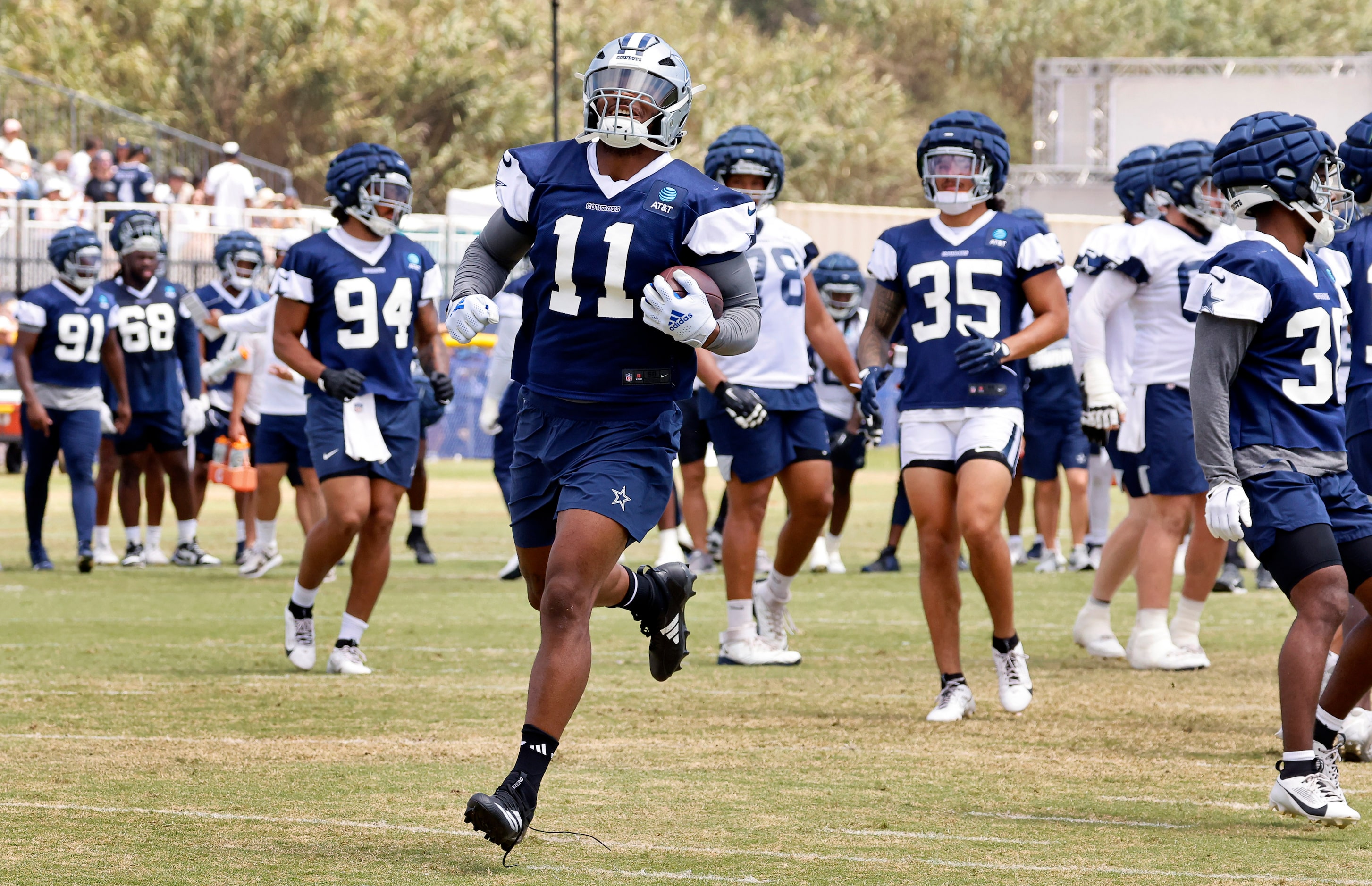 Dallas Cowboys linebacker Micah Parsons (11) smiles as he breaks away on a running play for...