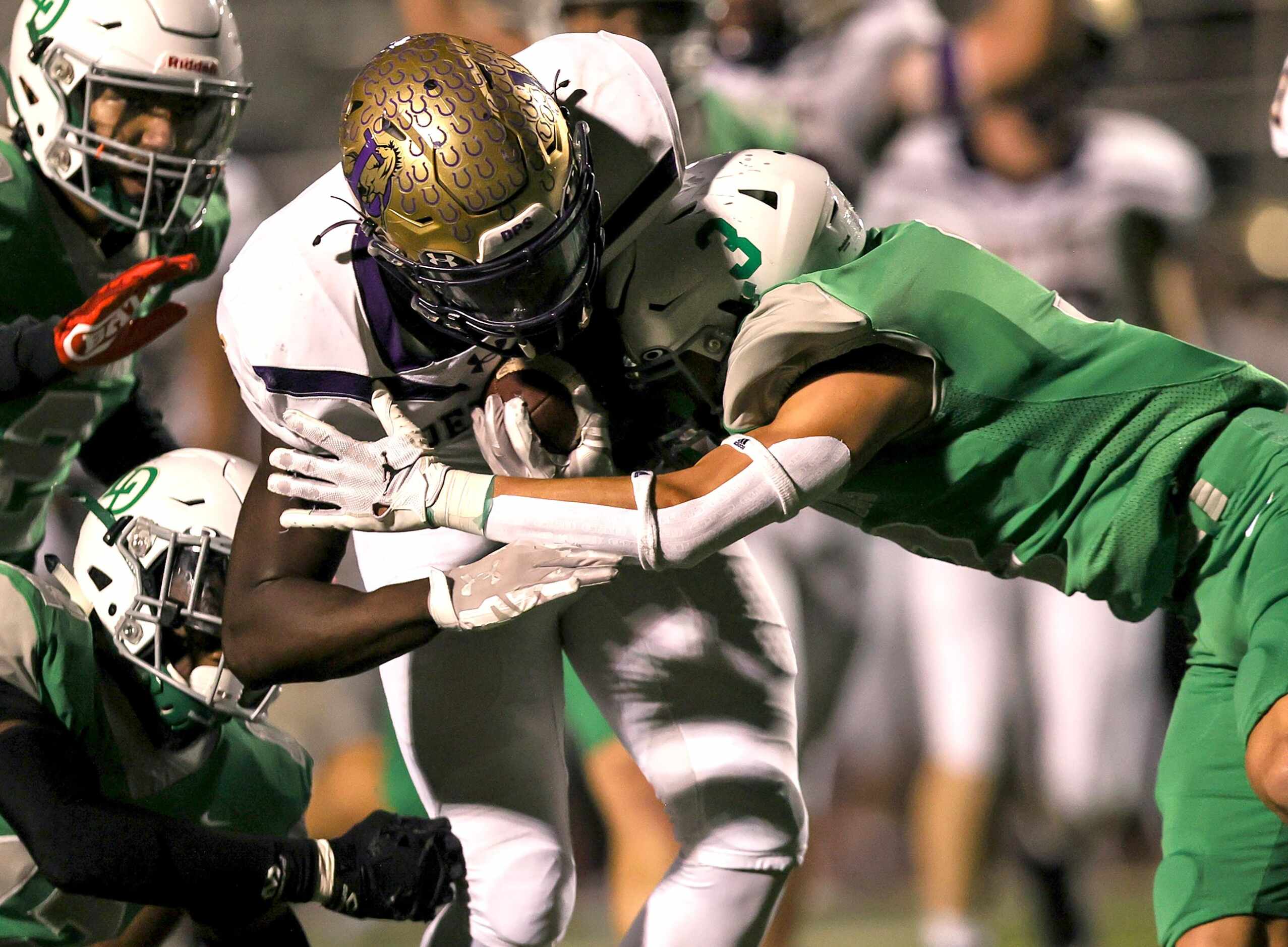 Denton running back Coco Brown (center) is hit hard by Lake Dallas defensive back Xinjin...