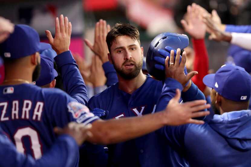 ANAHEIM, CALIFORNIA - APRIL 04:  Joey Gallo #13 of the Texas Rangers is congratulated in the...