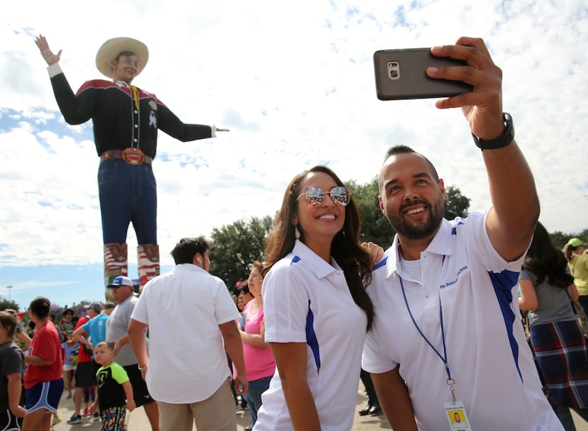 Dennis Jansen and Cassandra Jaramillo take a selfie with Big Tex at the State Fair of Texas...