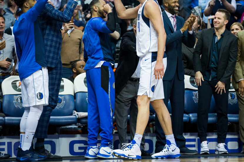 Dallas Mavericks forward Dirk Nowitzki (41) gets high-fives at the bench after passing Wilt...