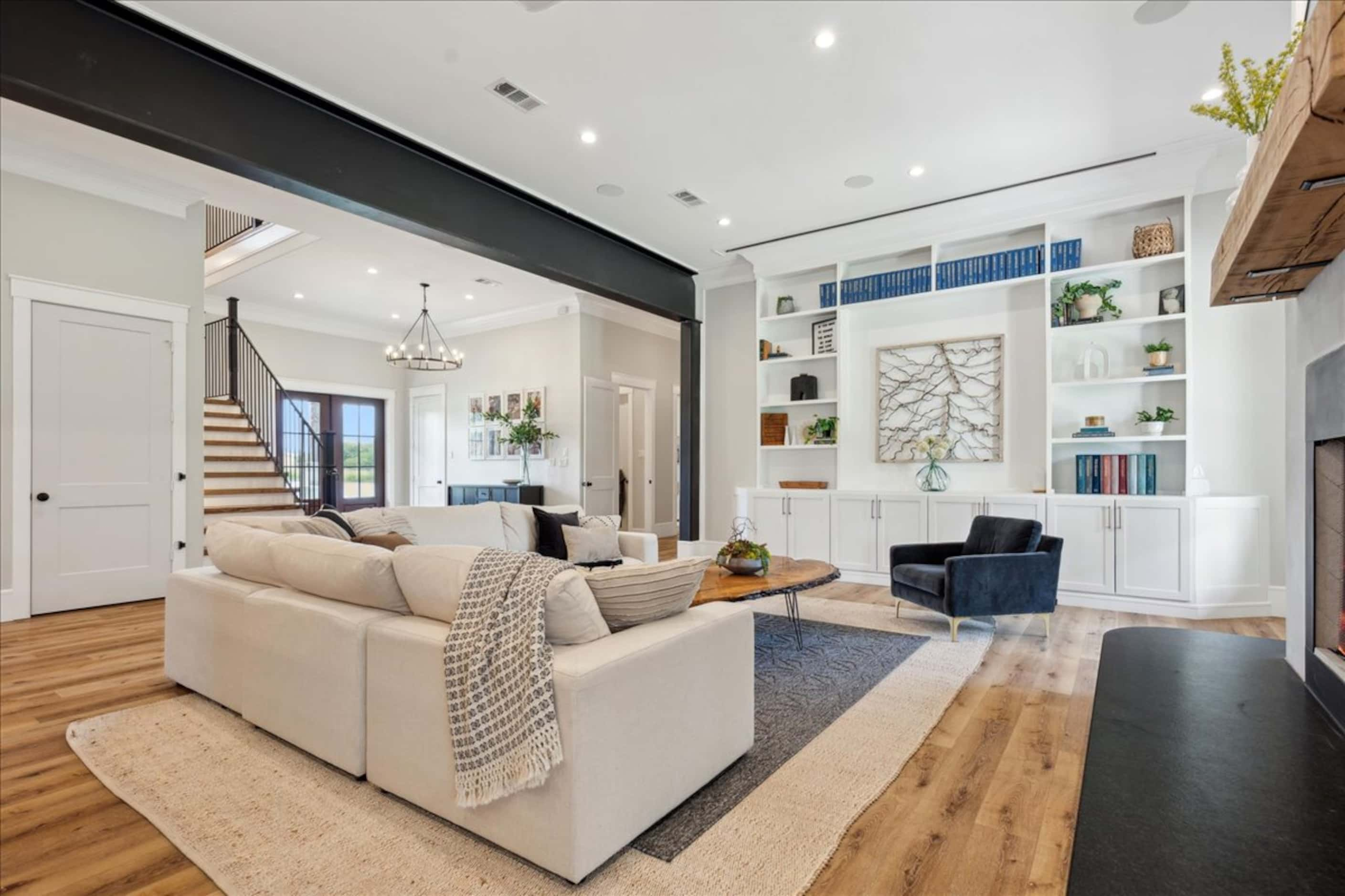 Open-concept living space with bookcases on one wall and a fireplace along the other