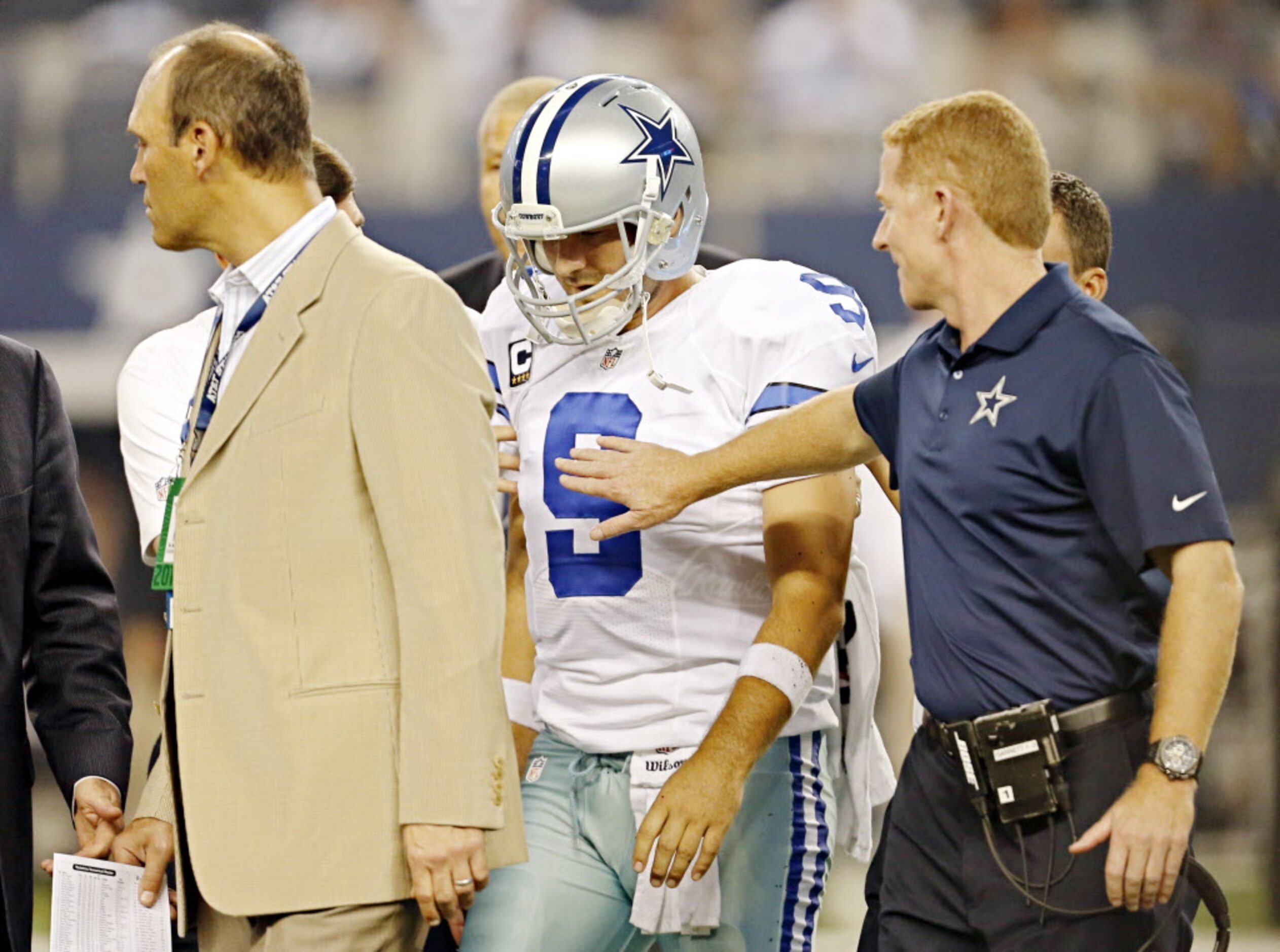 Dallas Cowboys head coach Jason Garrett (far right) pats Dallas Cowboys quarterback Tony...