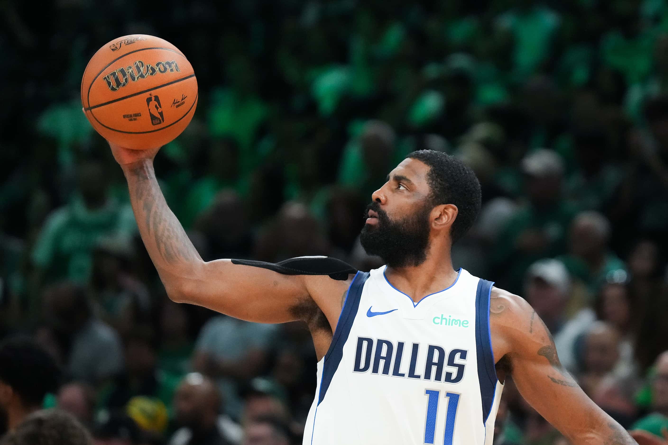 Dallas Mavericks guard Kyrie Irving reaches for the game ball before Game 5 of the NBA...