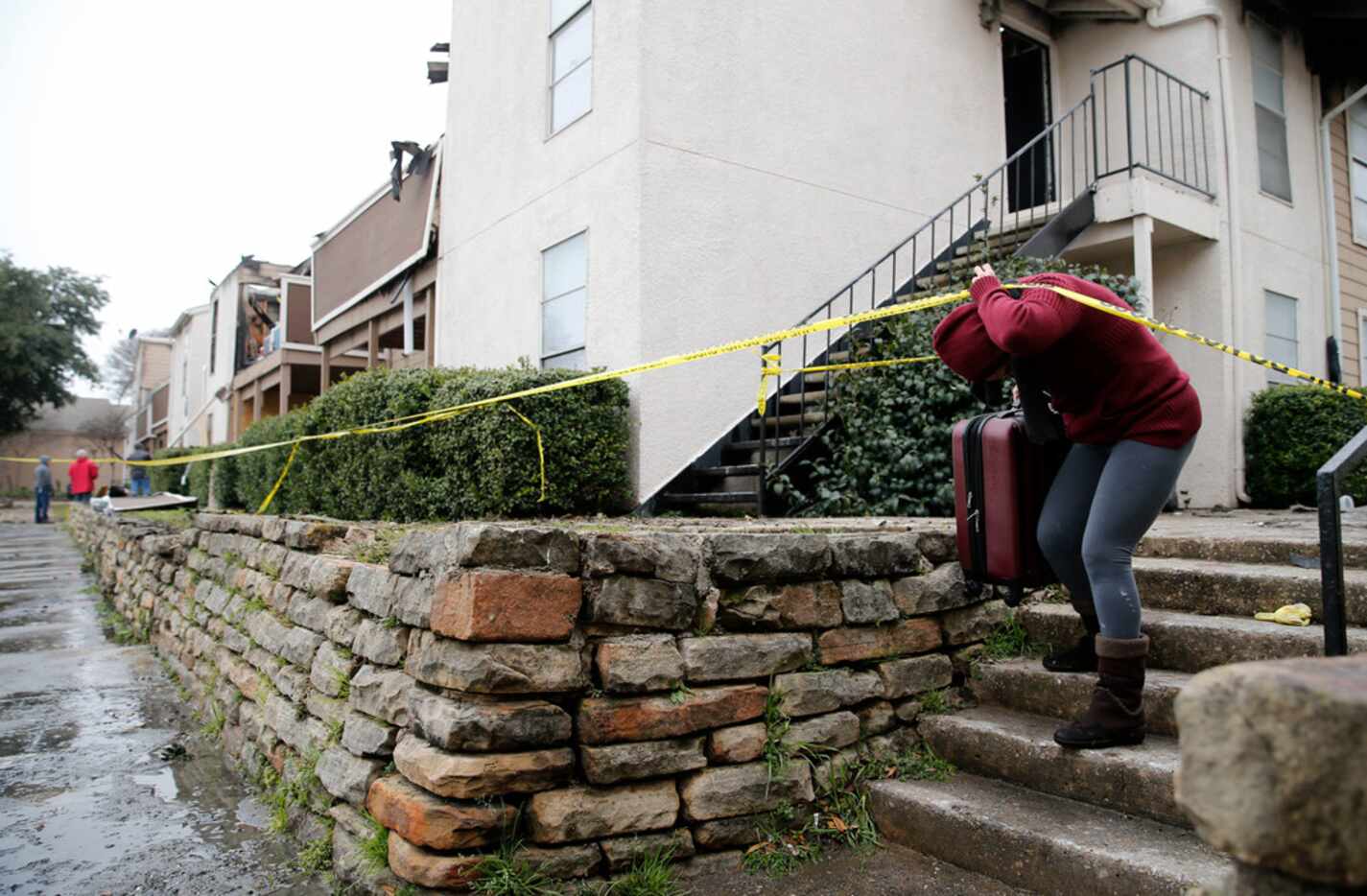 Yamilet Romero removes salvageable items from her apartment after a fire damaged eight units...