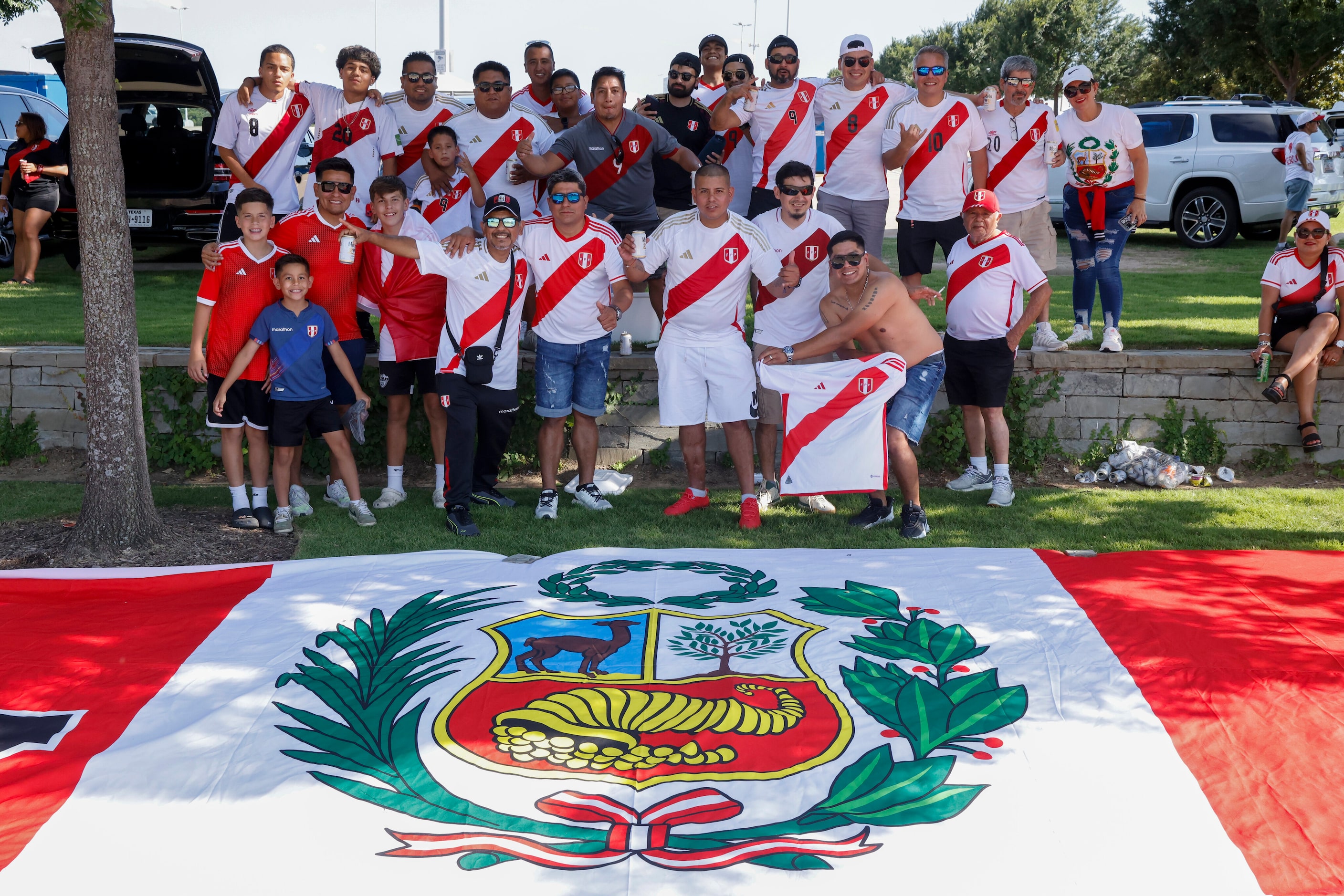 Peru soccer fans pose with a large Peruvian flag outside AT&T Stadium before a Copa America...